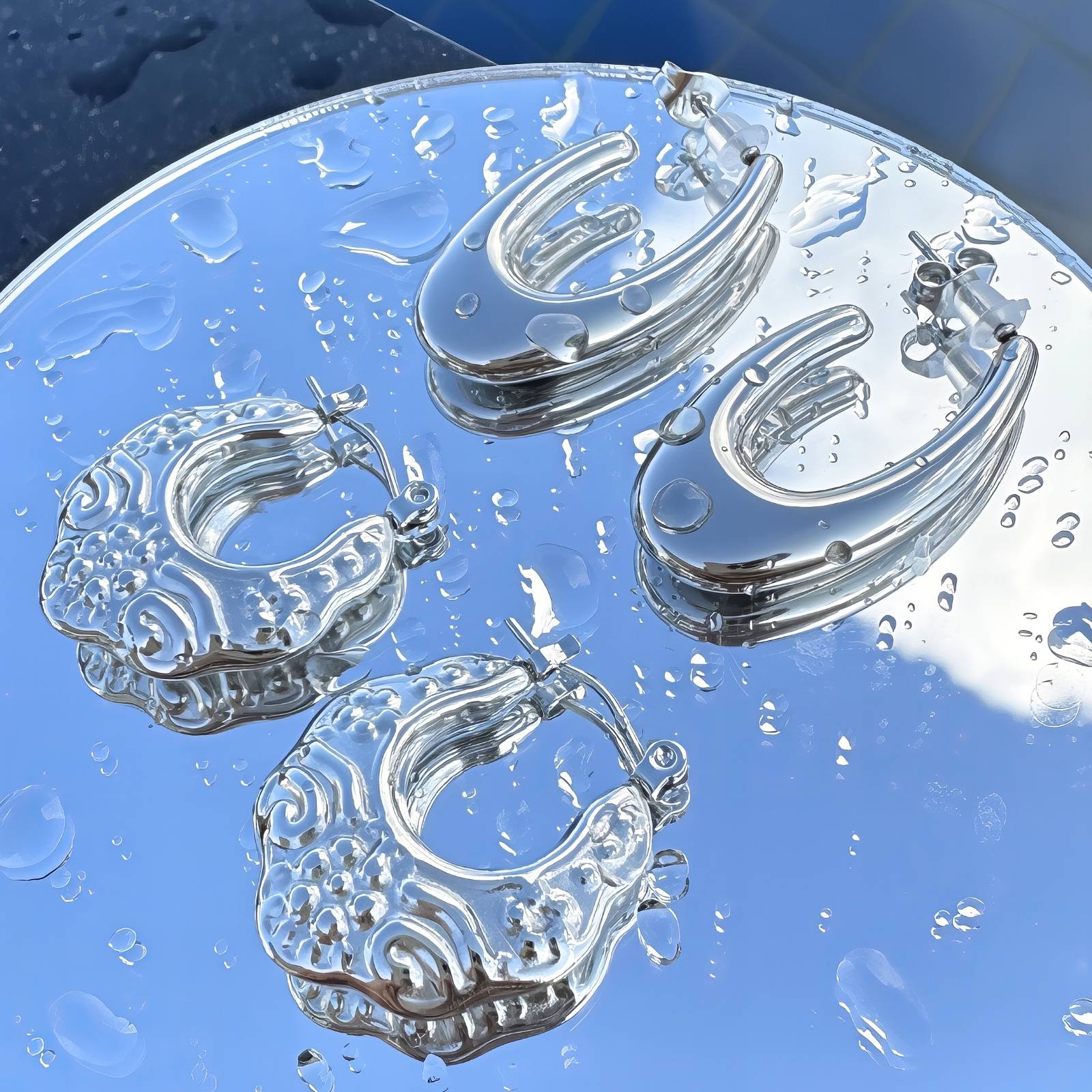 Liquid drop hoop earrings in stainless steel with a sleek, modern design and a polished finish.