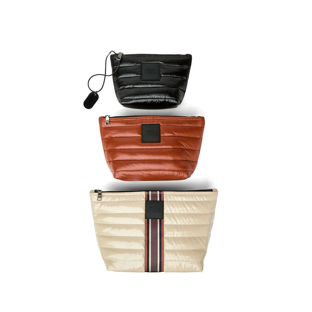 Blonde patent travel pouches with stripe detail, part of the Think Royln Travel Trio organizational set.