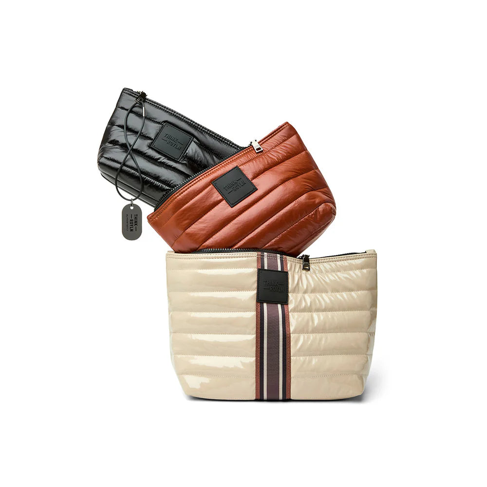 Blonde patent travel trio organizational pouches with stripe design by Think Royln, ideal for travel organization.