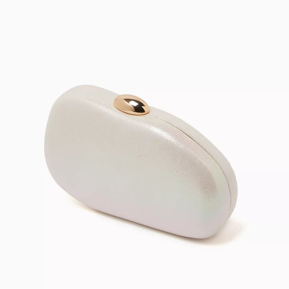 Dolce Vita Dionne hardshell clutch in white with black accents, featuring a sleek, structured design and silver clasp closure.