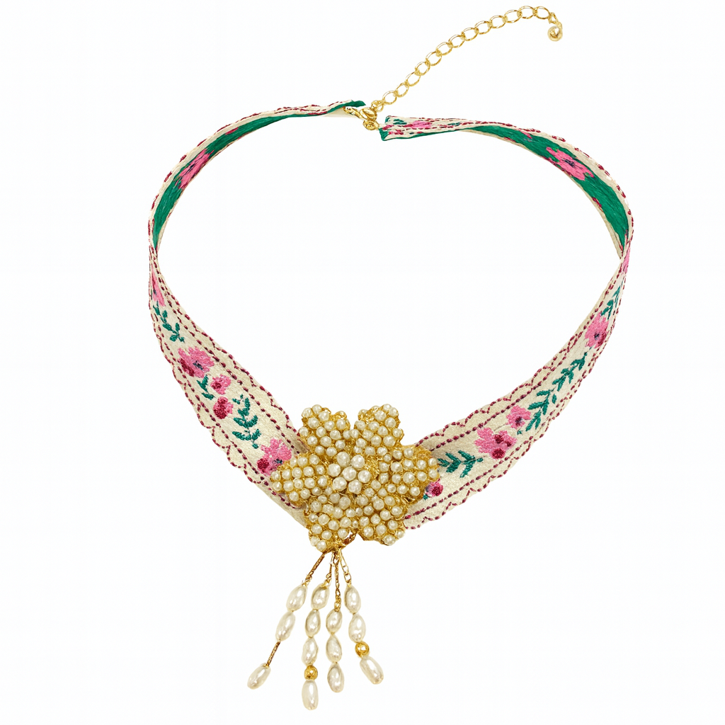 Decorative necklace with floral patterns and pearl-like elements on a white background