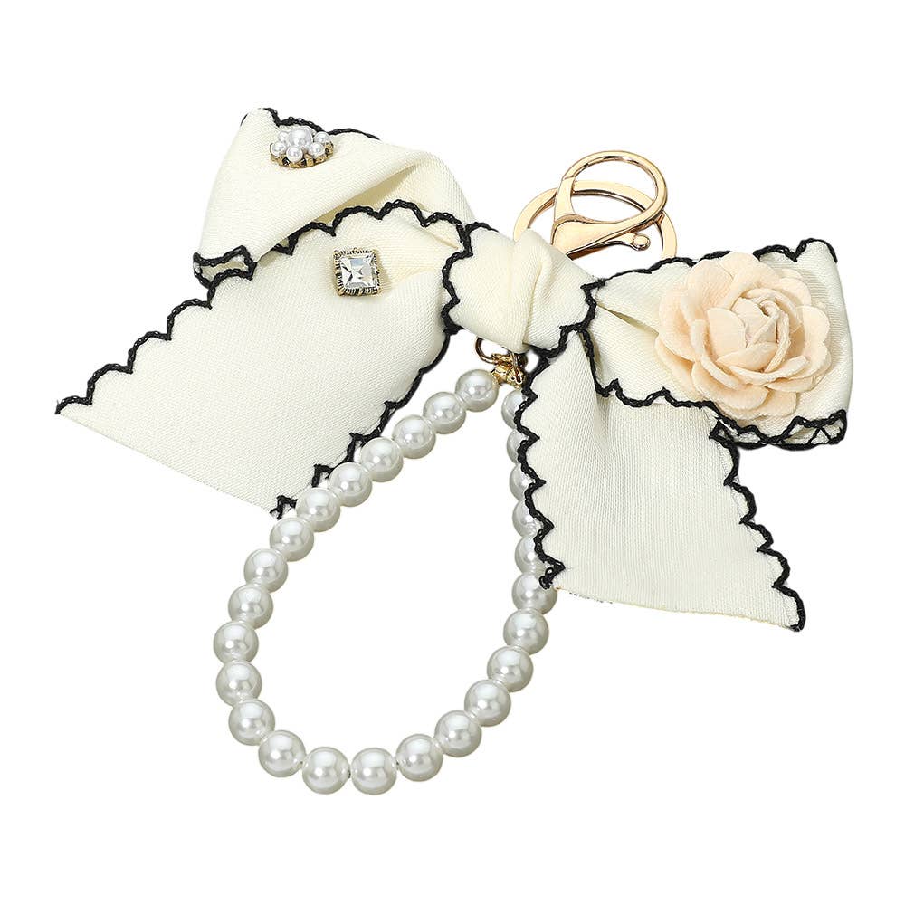 Flower rhinestone accent pearl loop bow keychain bag charm with decorative jewelry elements on a keyring.