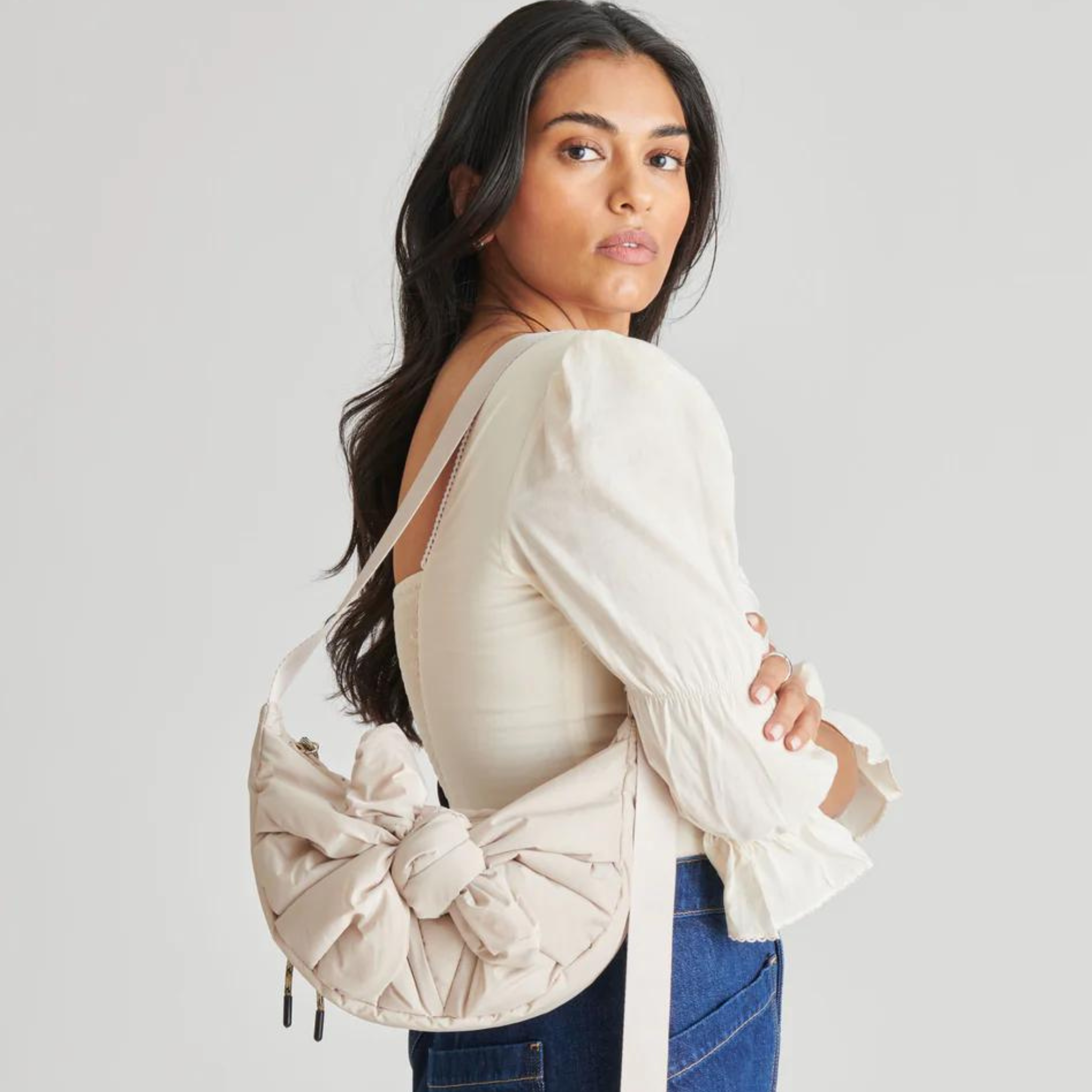 Dolce Vita Nancy shoulder bag with beige leather exterior and gold-tone hardware, featuring a sleek, stylish design.