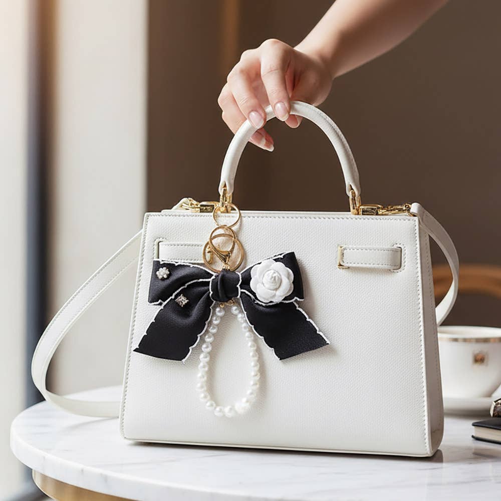 Flower rhinestone accent pearl loop bow keychain bag charm with rhinestone details and decorative design.