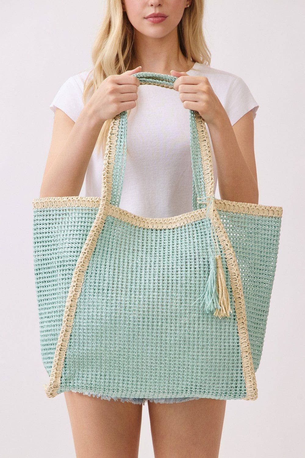 Two tone woven straw beach tote bag with leather handles, stylish and spacious for summer outings.