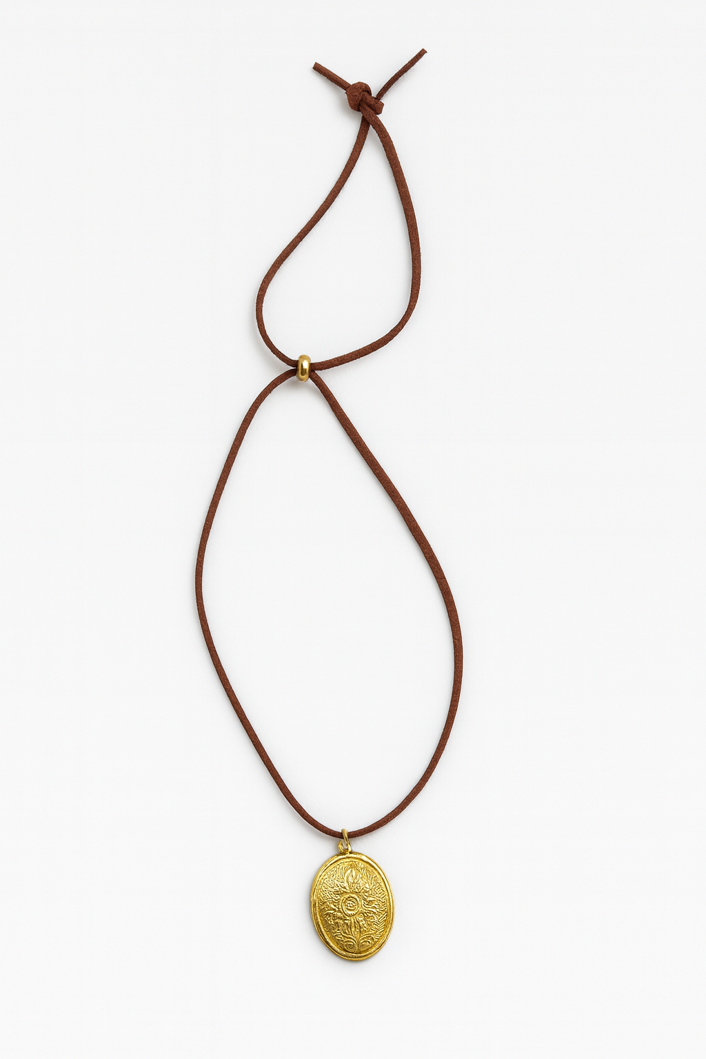 Gold pendant necklace on a brown cord against a white background
