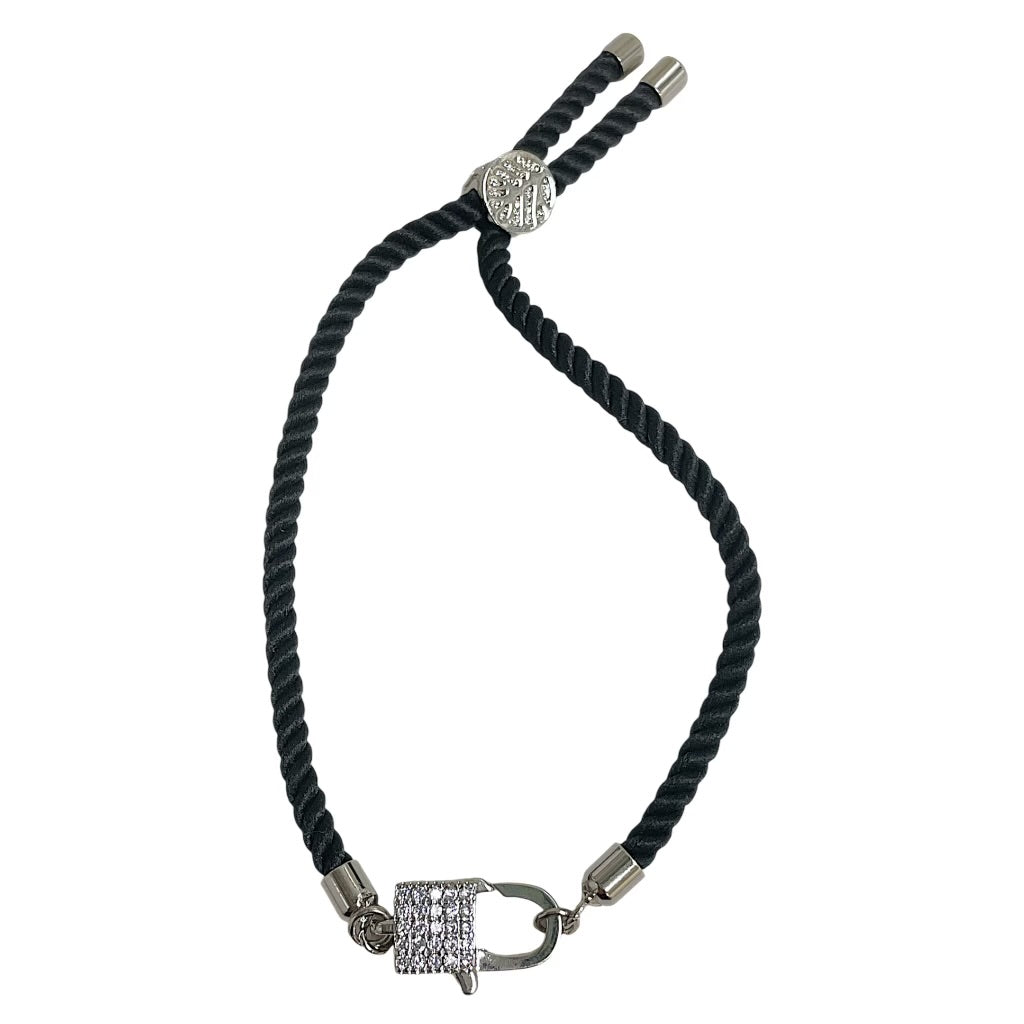 Brenda Perruzza Jewelry rope pulley bracelet with adjustable cord and decorative metal accents on a neutral background.