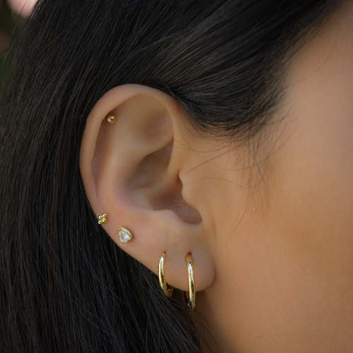 Pink and white minimalist huggie hoop earrings from Private Label with cute illustrative design for beauty and fashion.
