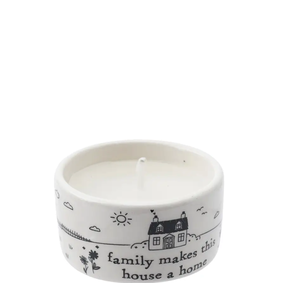 Ceramic tealight holder by private label with "family makes this..." design, perfect for warm ambient lighting.