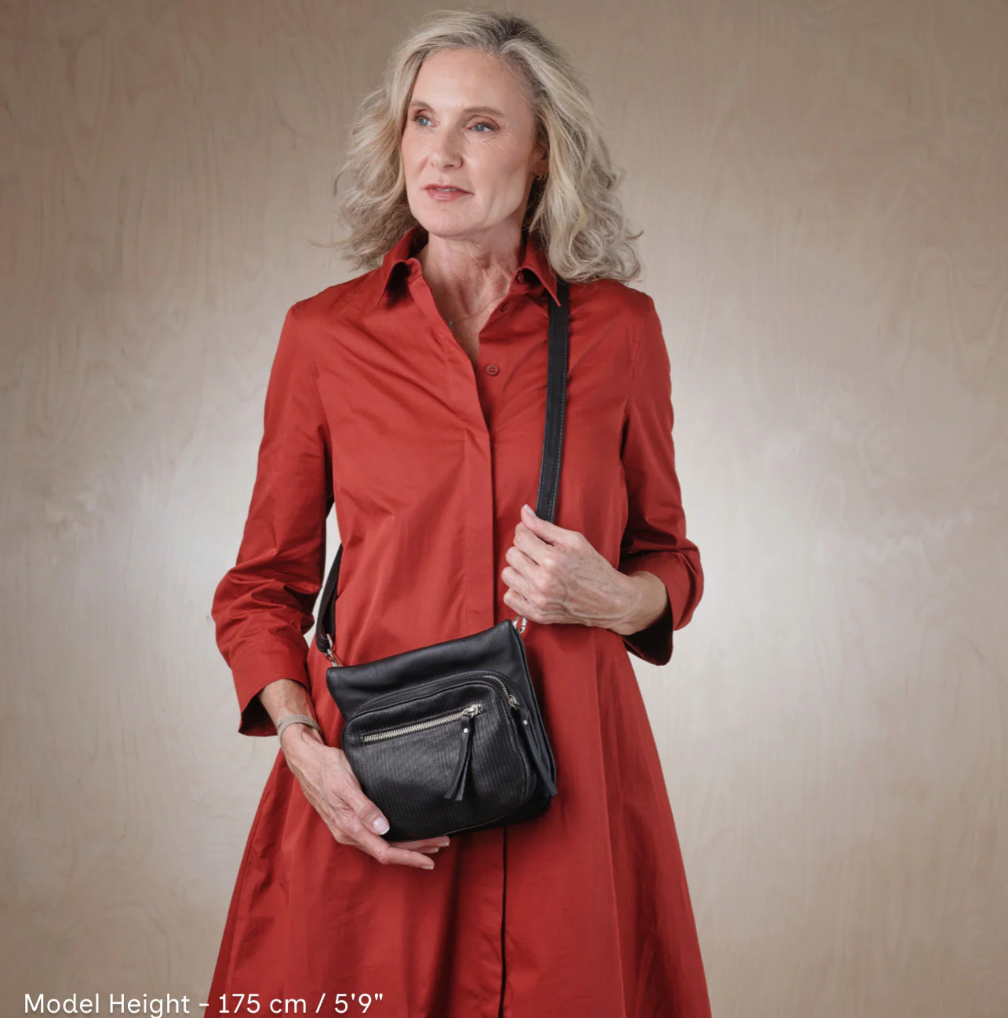 Daniella Lehavi Memphis Crossbody Bag in black leather with adjustable strap, front flap, and minimalist design.