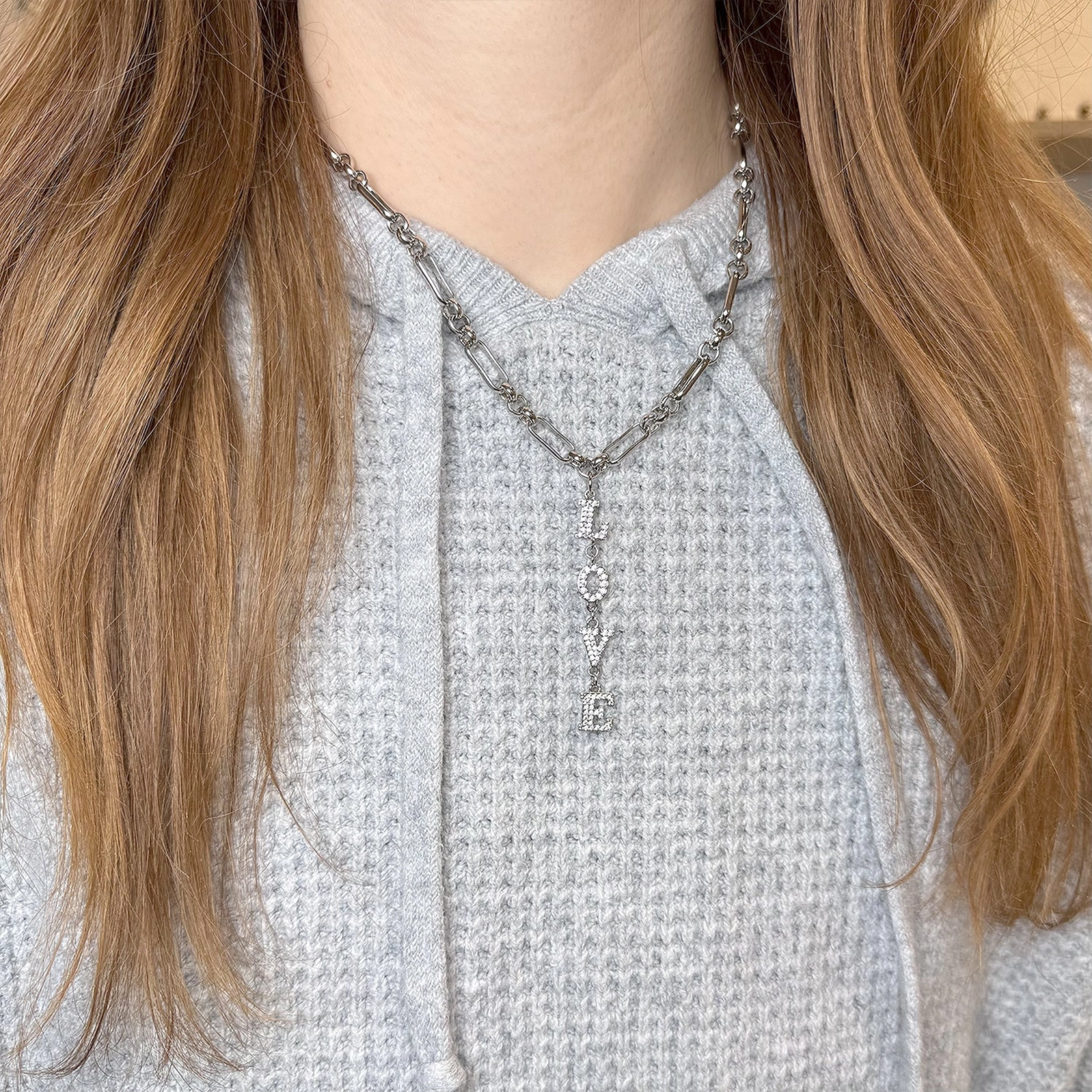 Love Lisa Maeve Love Drop Necklace featuring a delicate heart and bow charm, perfect for elegant jewelry styling.