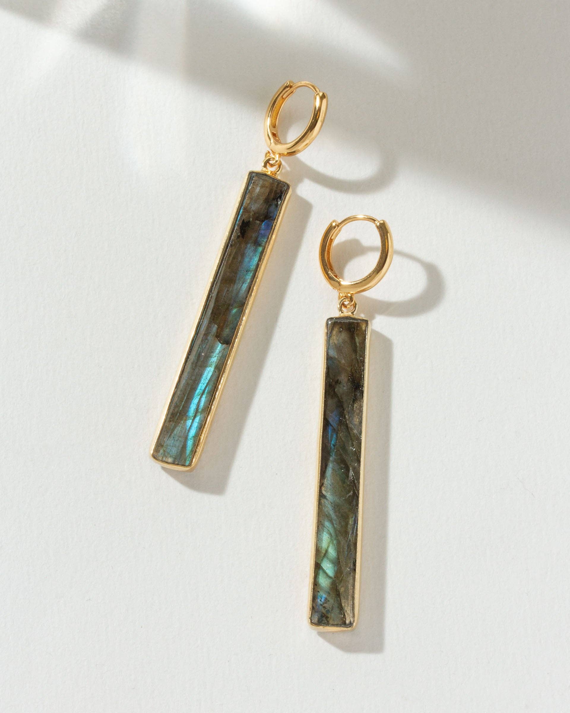 Gold earrings with Labradorite stones on a white background
