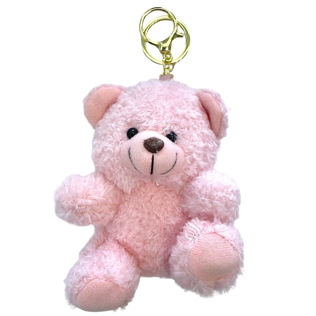Pink plush teddy bear keychain with a cute smiling face and soft fur, perfect for attaching to bags or keys.