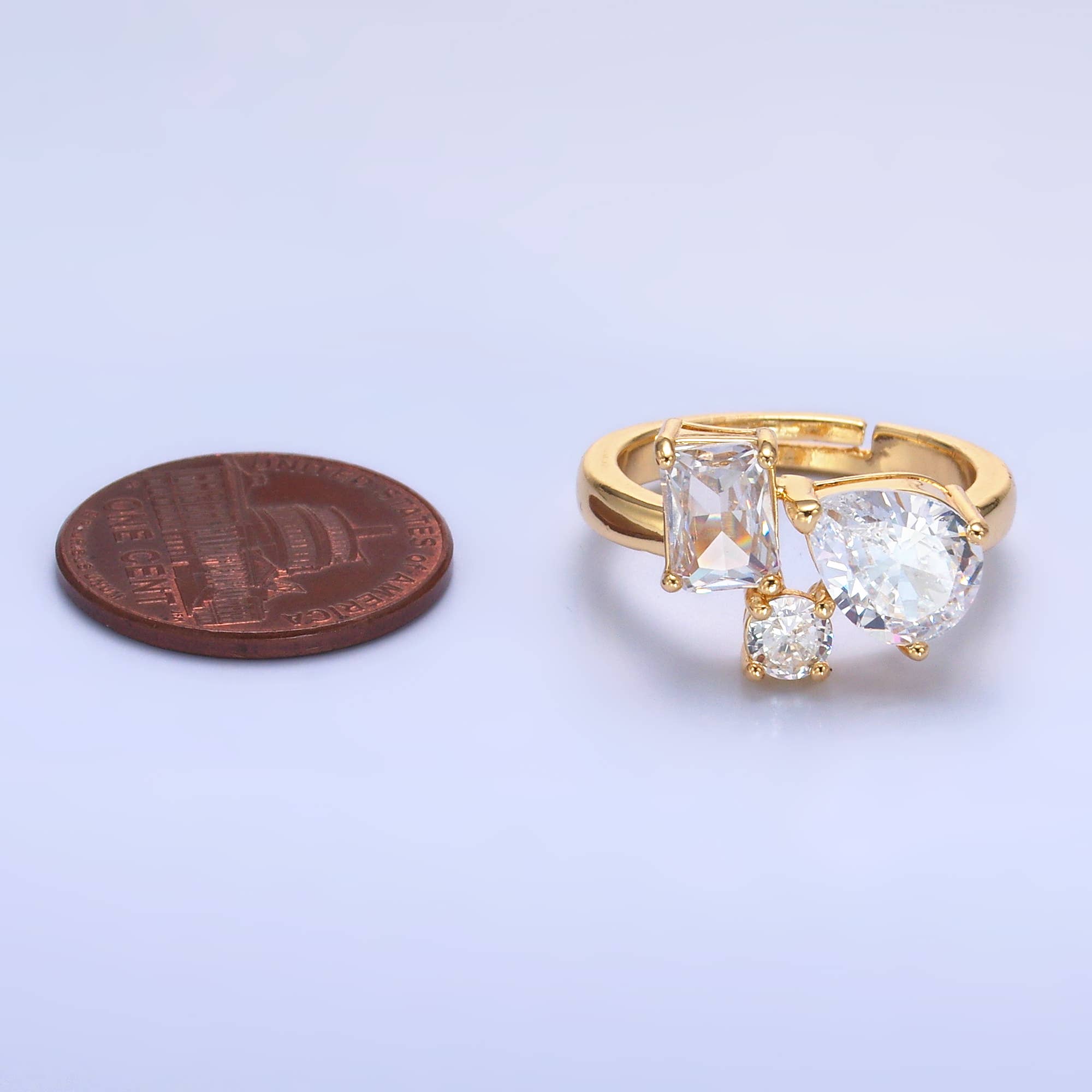 Dainty gold adjustable ring with multi-shaped clear CZ stones, featuring a sleek, elegant design and fine craftsmanship.