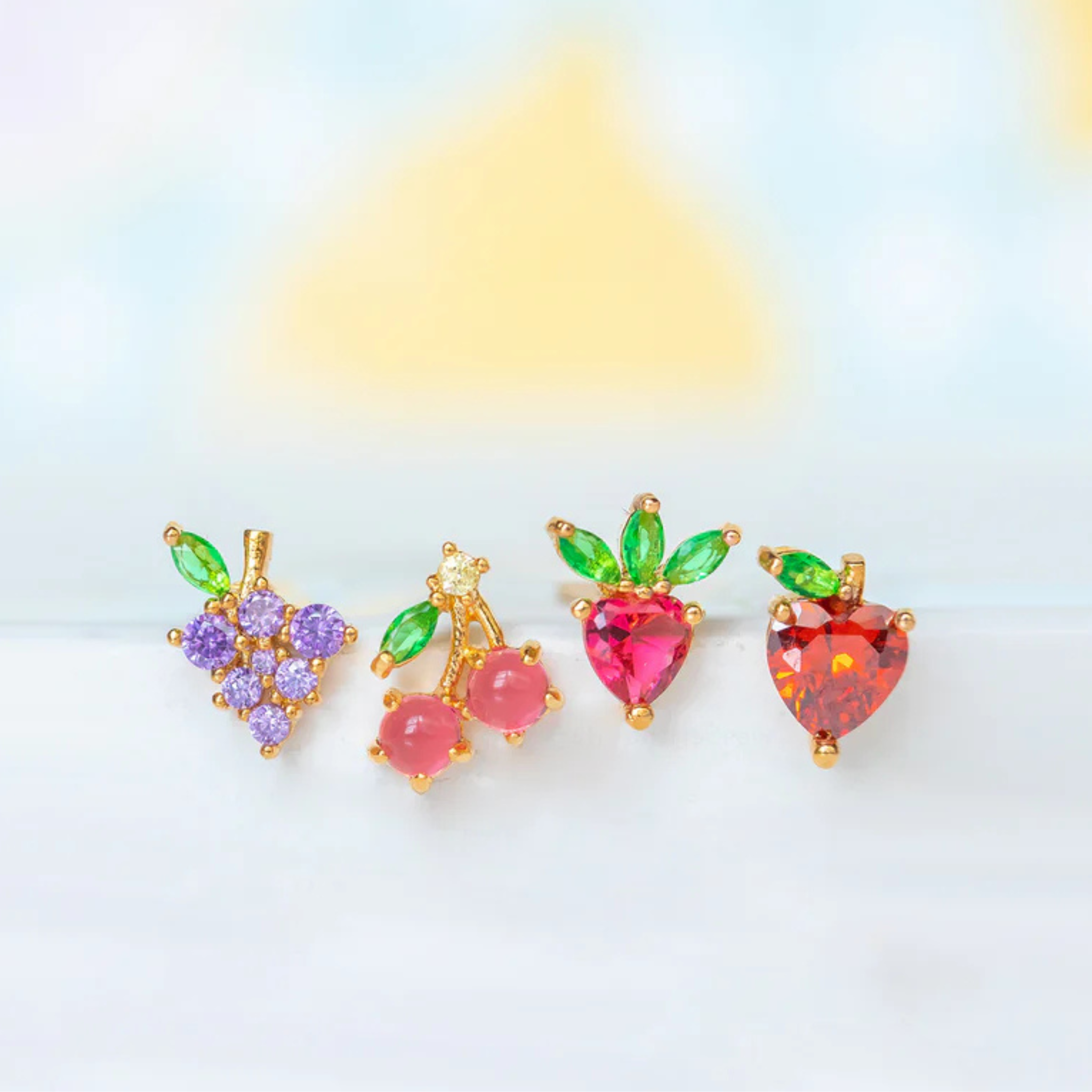 Girls Crew fruit basket stud earrings featuring colorful fruit designs on a gold-tone background.