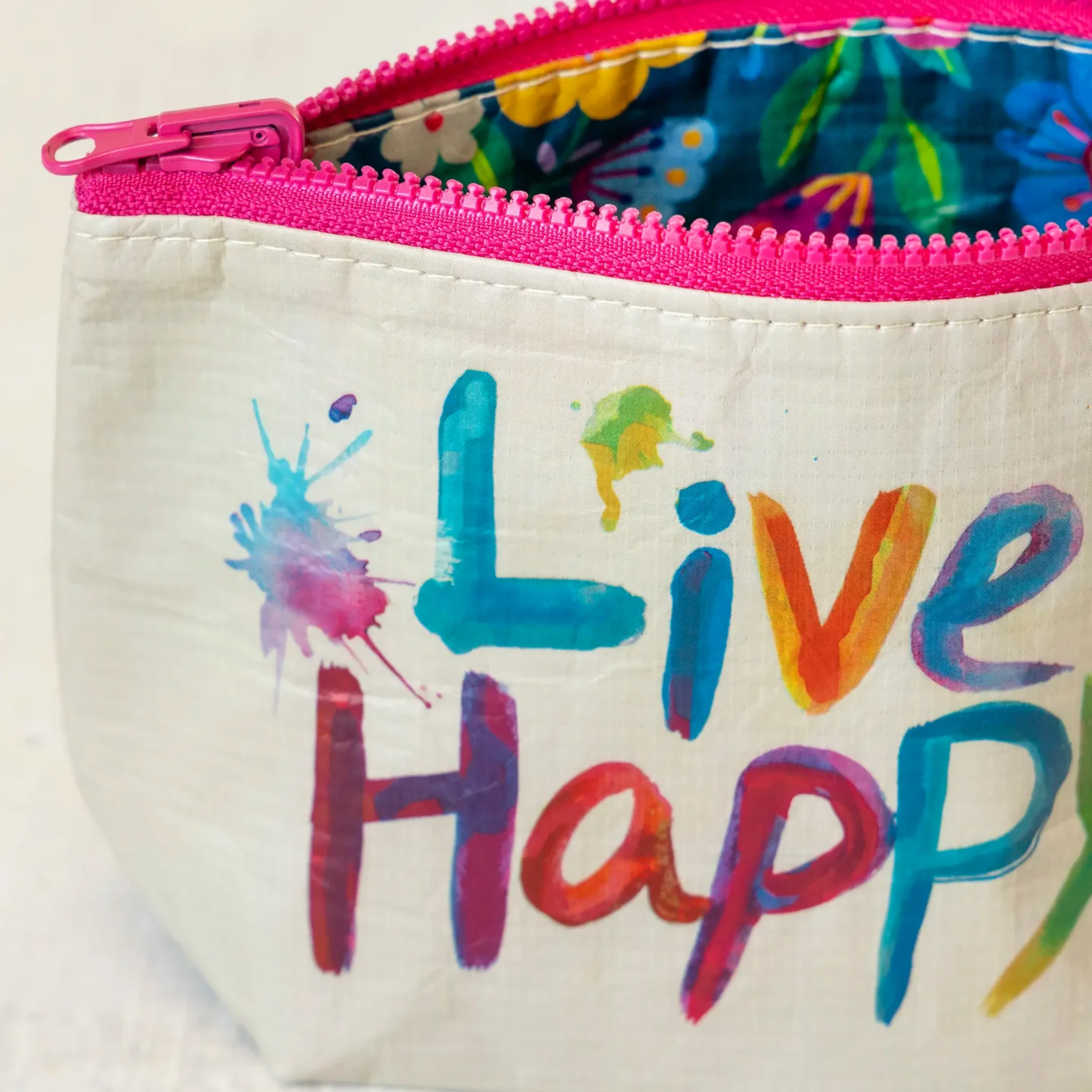 Small Natural Life recycled reversible zipper pouch for travel, showing eco-friendly design with colorful patterns and compact size.