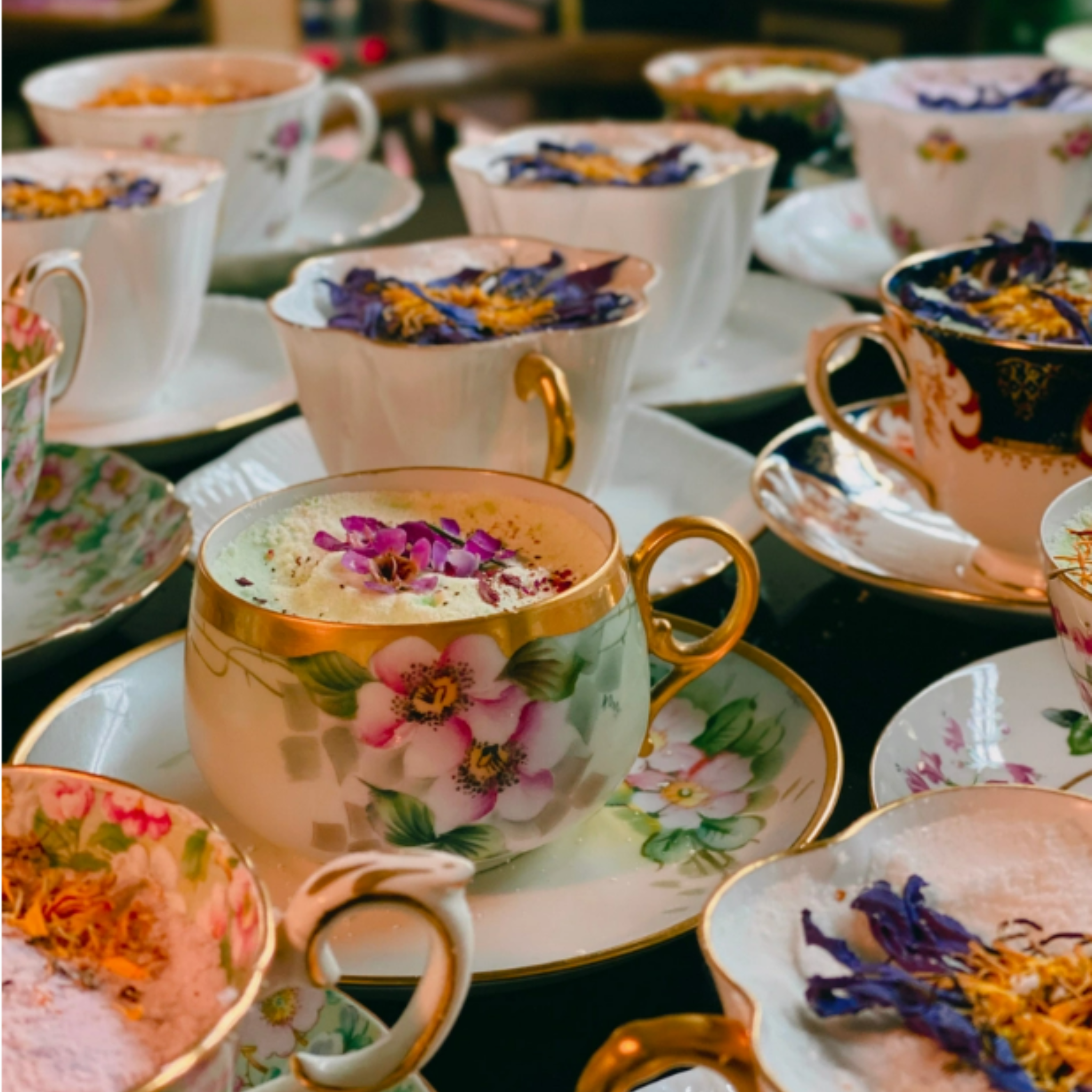 Antique tea cup bath bombs by Witchy Woman World Apothecary in a floral design, resting on a wooden surface.