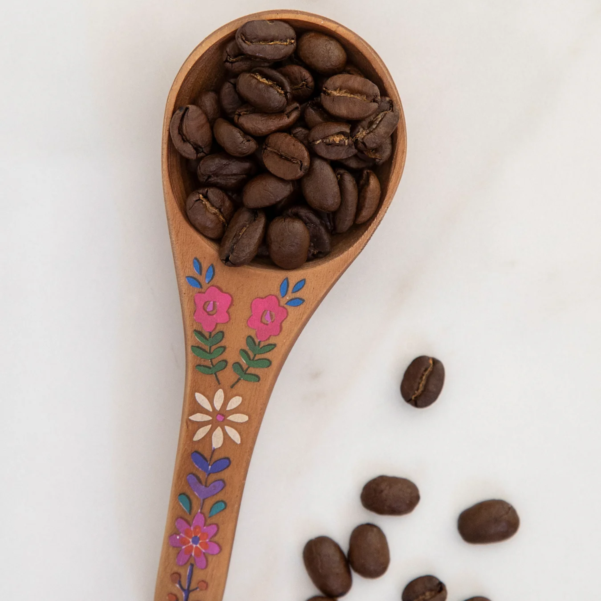 Natural Life wooden coffee scoop with "But First Coffee" engraved, perfect for measuring coffee beans in the kitchen.