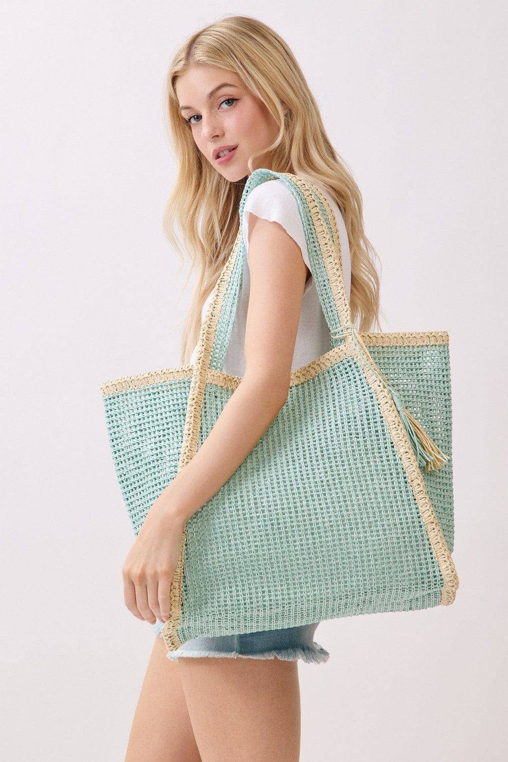 Two tone woven straw beach tote bag with leather handles, stylish and spacious for beach outings and summer days.