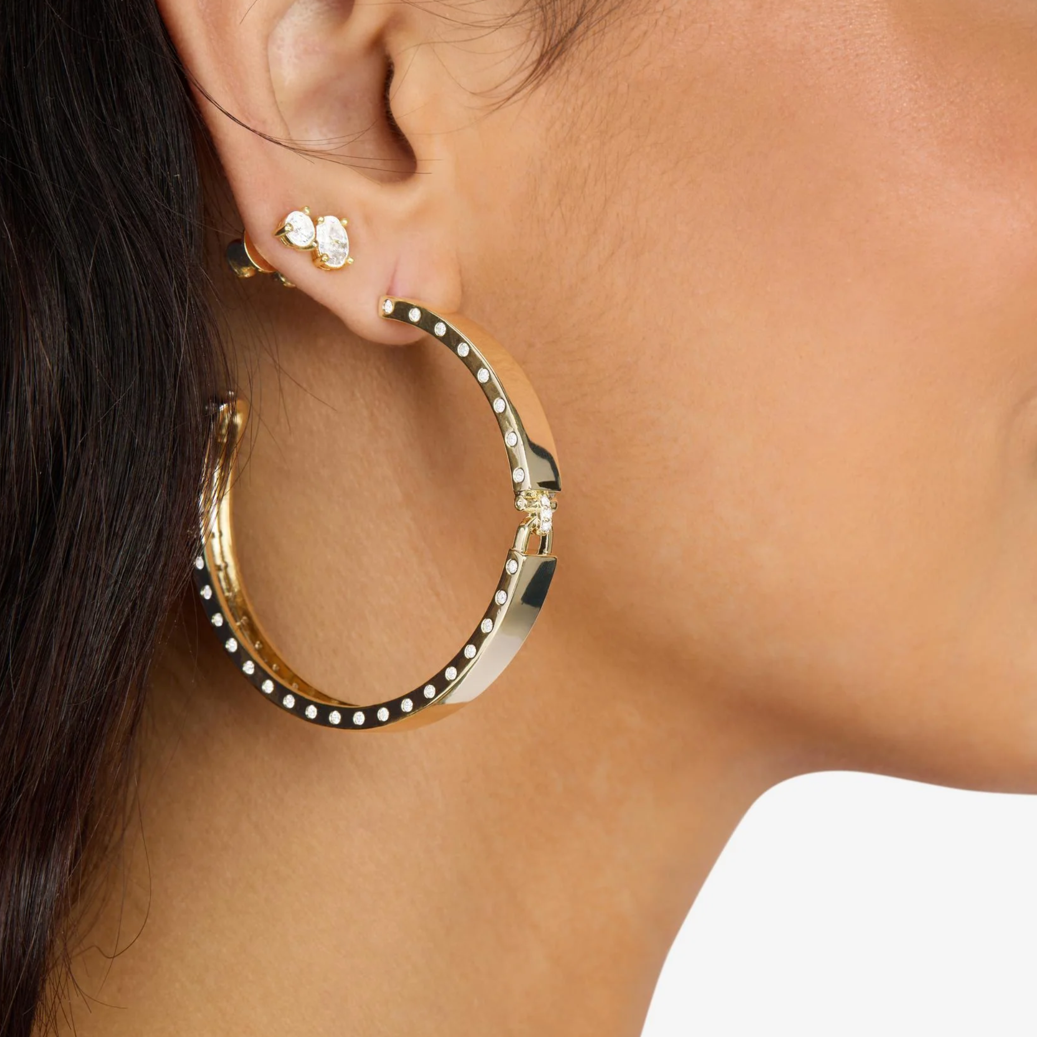 Melinda Maria Ashley Lock Hoops 2-inch gold earrings with white diamondette accents, showcasing elegant hoop design.