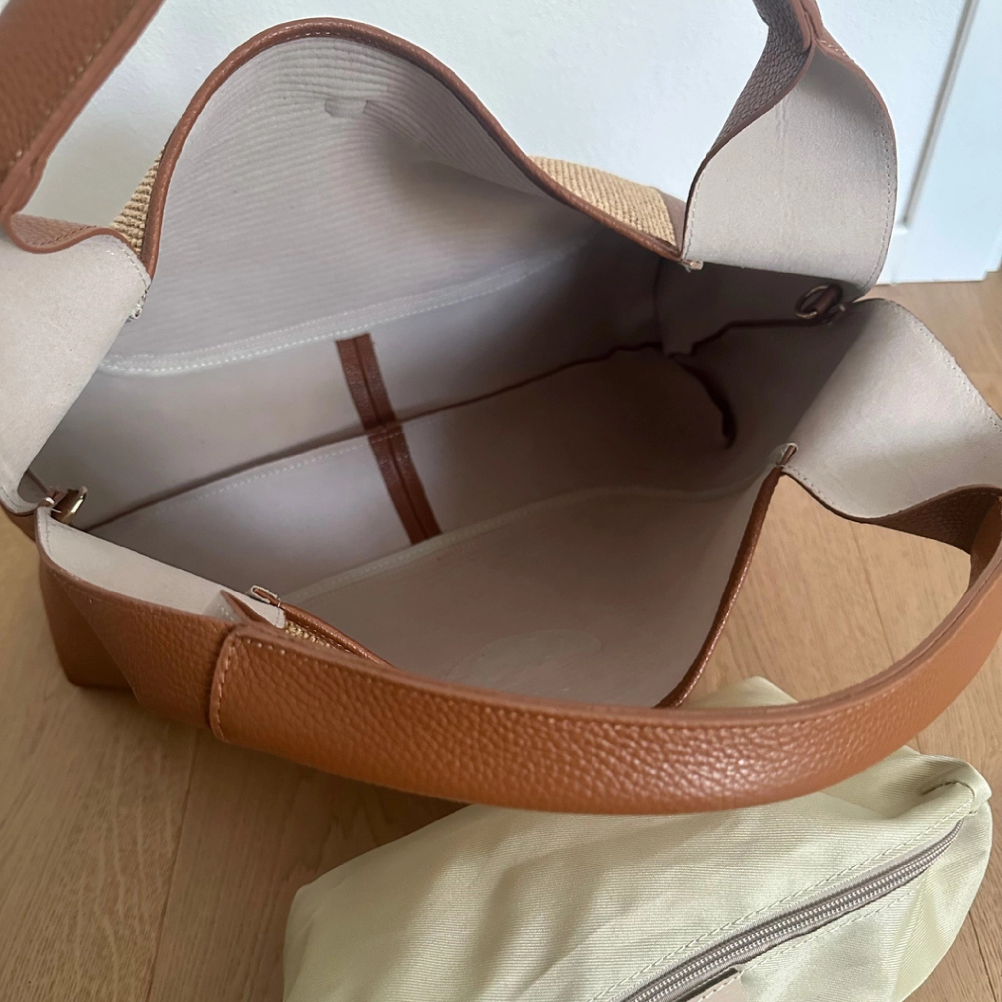 Private label Riviera Tote handbag with tan leather handles and beige canvas body, featuring a spacious interior and stylish design.