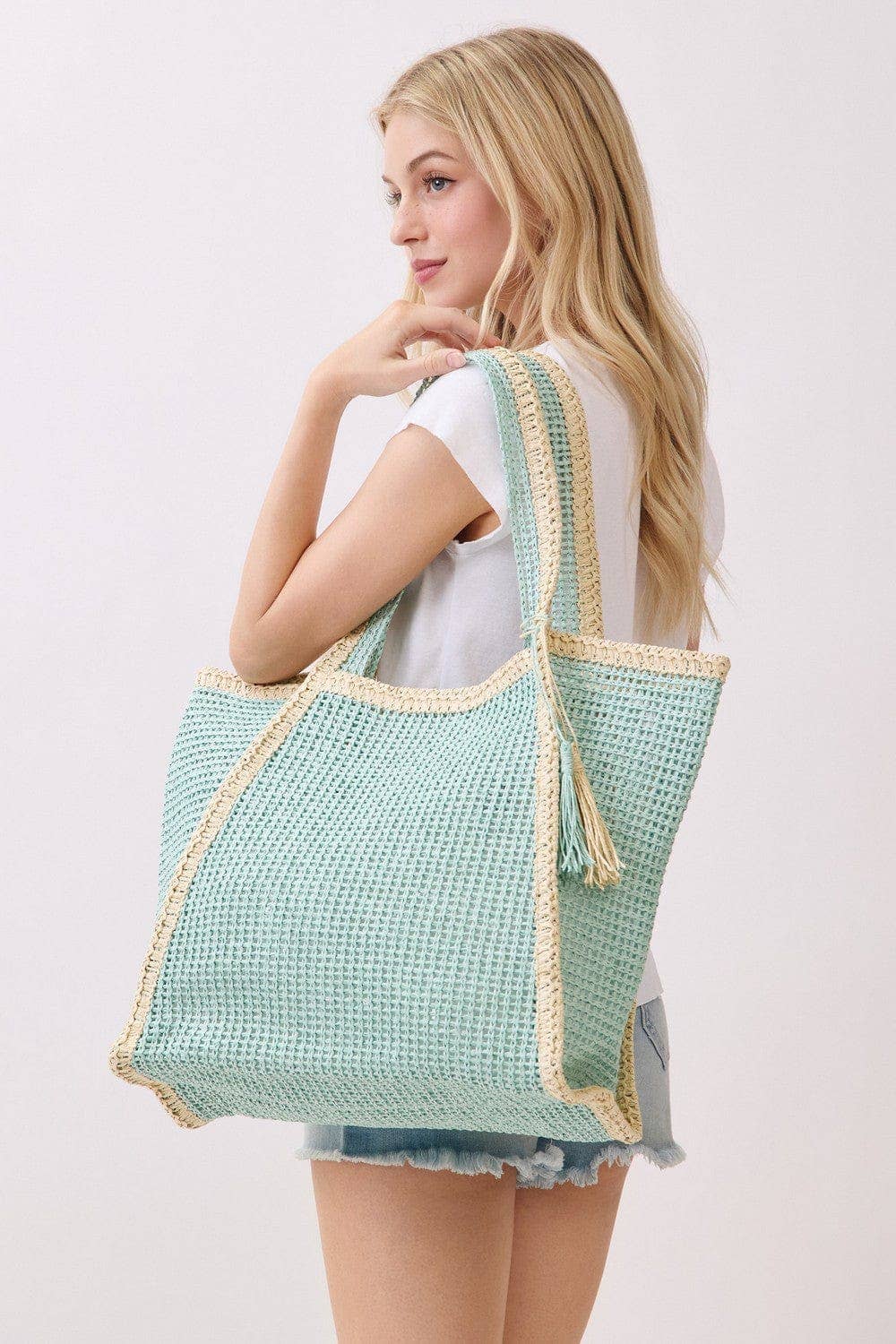 Two tone woven straw beach tote bag with sturdy handles, perfect for carrying essentials to the beach or pool.