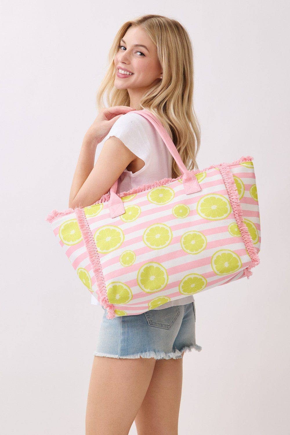 Lemon stripe fringe beach tote bag with woven handles, stylish and spacious for carrying beach essentials.