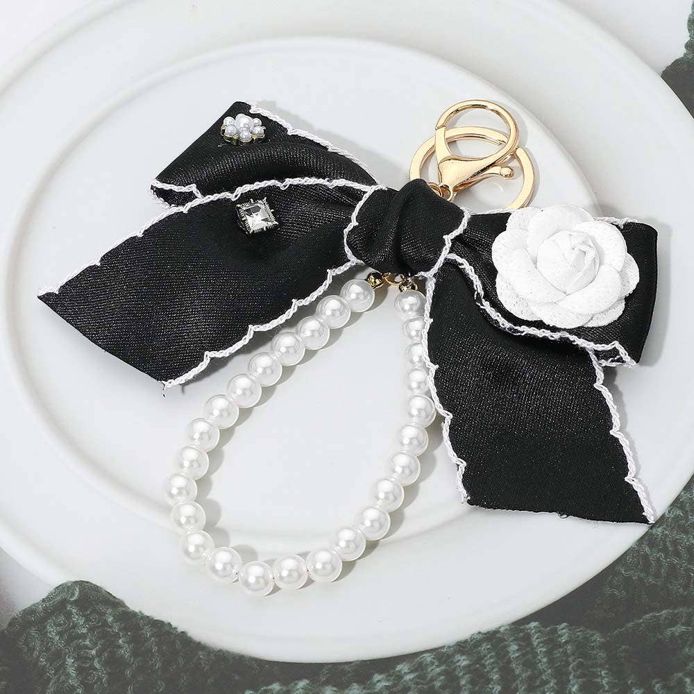 Flower rhinestone accent pearl loop bow keychain with decorative charm, ideal as a stylish bag accessory.