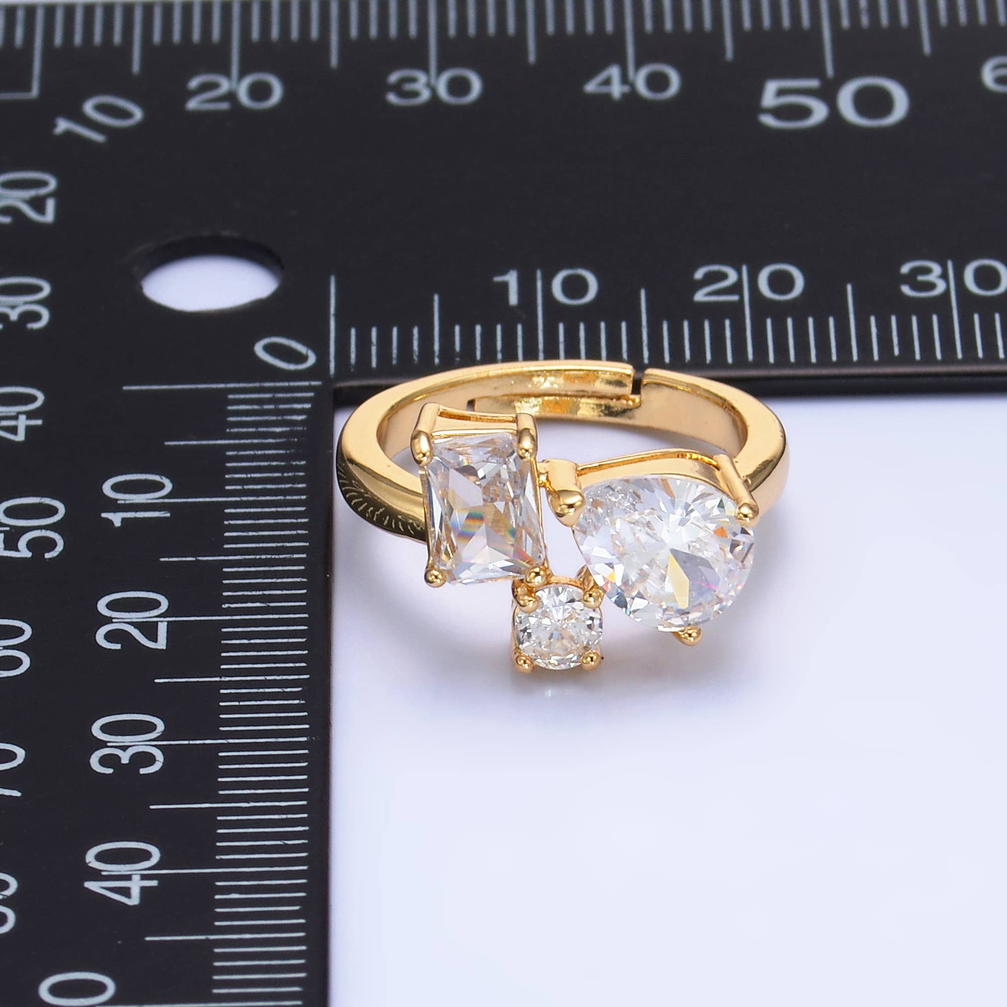 Dainty gold adjustable ring with multi-shaped clear CZ stones, featuring a delicate design and shiny gemstone accents.