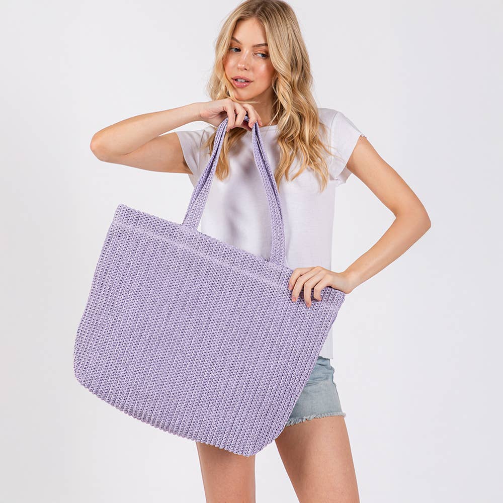 Solid crochet straw tote bag, a stylish private label beach handbag with woven design and sturdy handles.