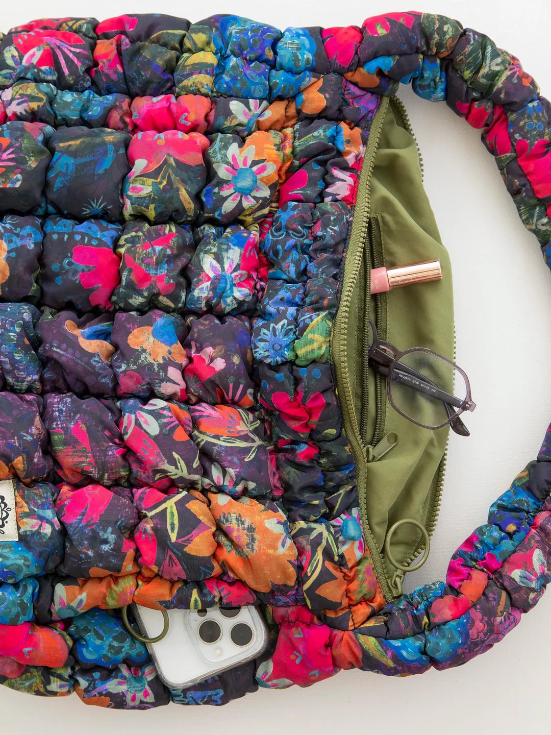Natural Life Puffy Fit-It-All Bag shoulder bag with quilted design, adjustable strap, and multiple compartments for versatile use.