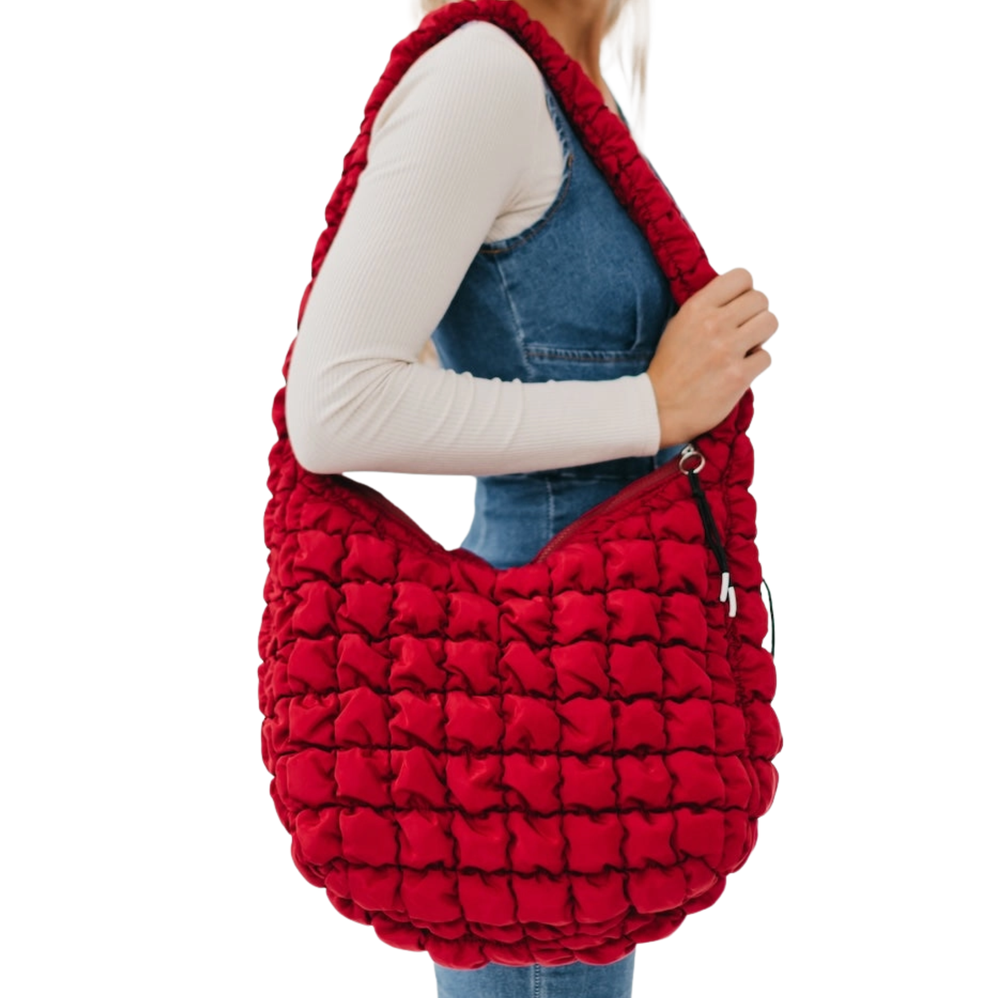 Red textured handbag held by a person on a white background