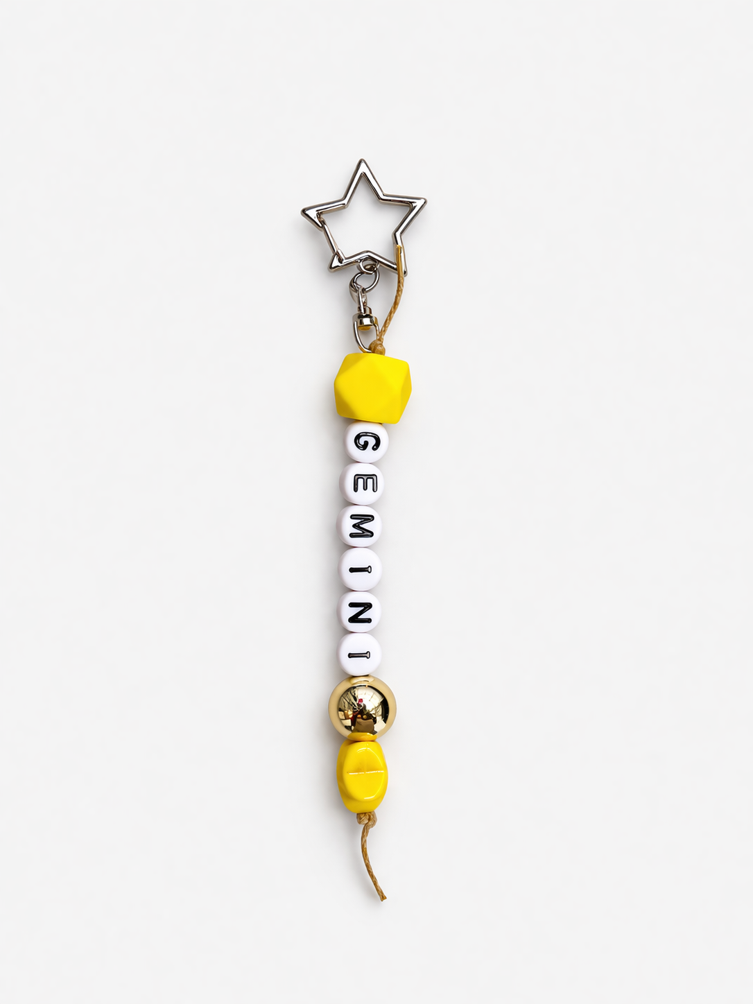 Jules by the Sea Zodiac keychain featuring a circular pendant with zodiac symbols and a metal keyring.