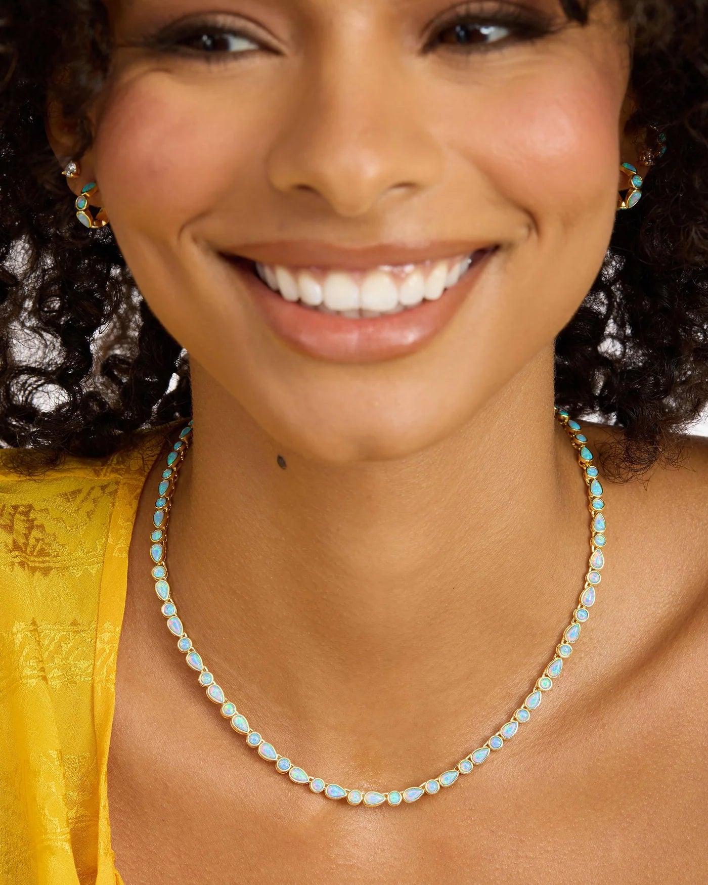 Gold Isla Tennis Necklace by Melinda Maria featuring blue opal stones, 16 inches in length, elegantly displayed.