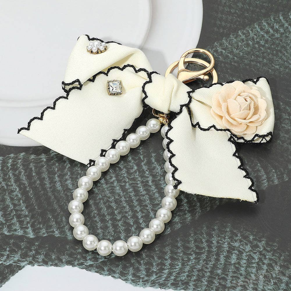 Flower rhinestone accent pearl loop bow keychain bag charm with decorative beads and a metal clasp, ideal for accessories.