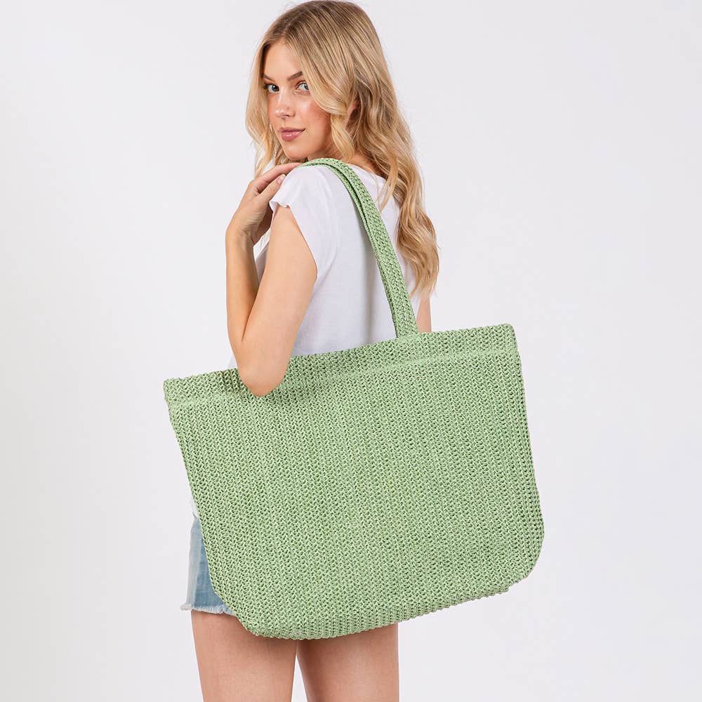 Handmade crochet straw tote bag by Private Label, stylish beach bag with woven texture and spacious interior for summer outings.