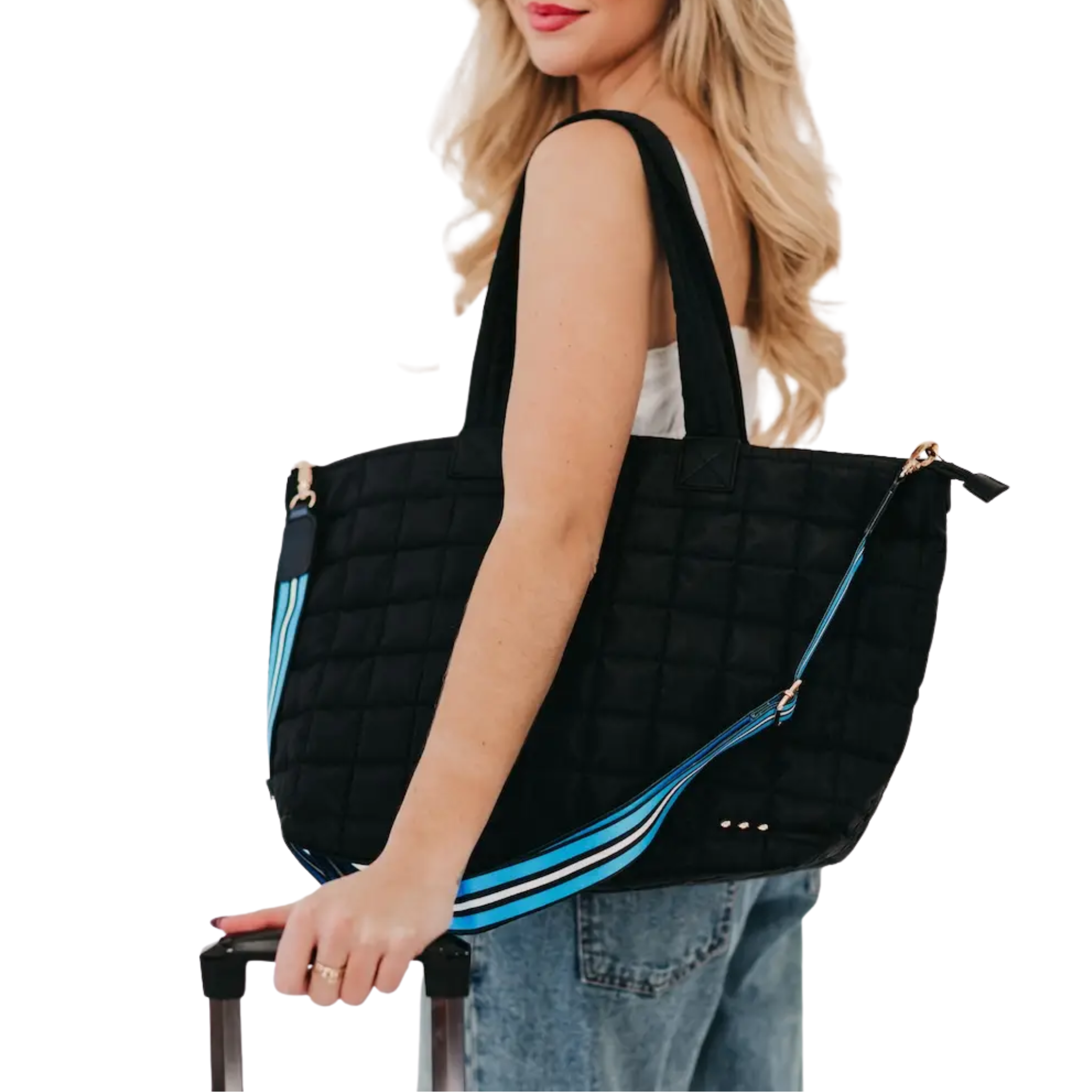 Woman holding a black quilted tote bag with blue accents on a white background