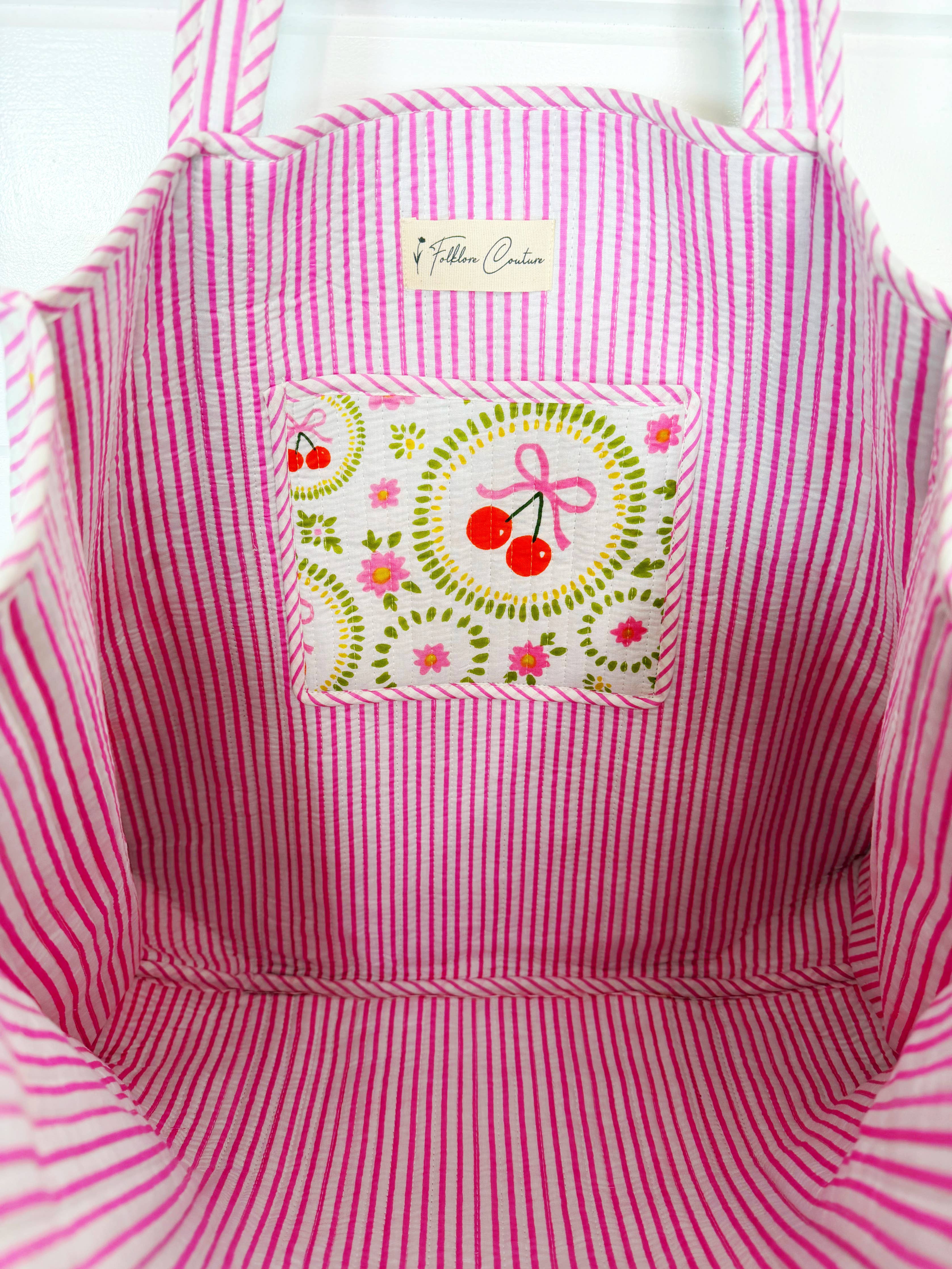 Large quilted tote bag by Folklore Couture featuring white cherry and bow design, ideal for travel and everyday use.