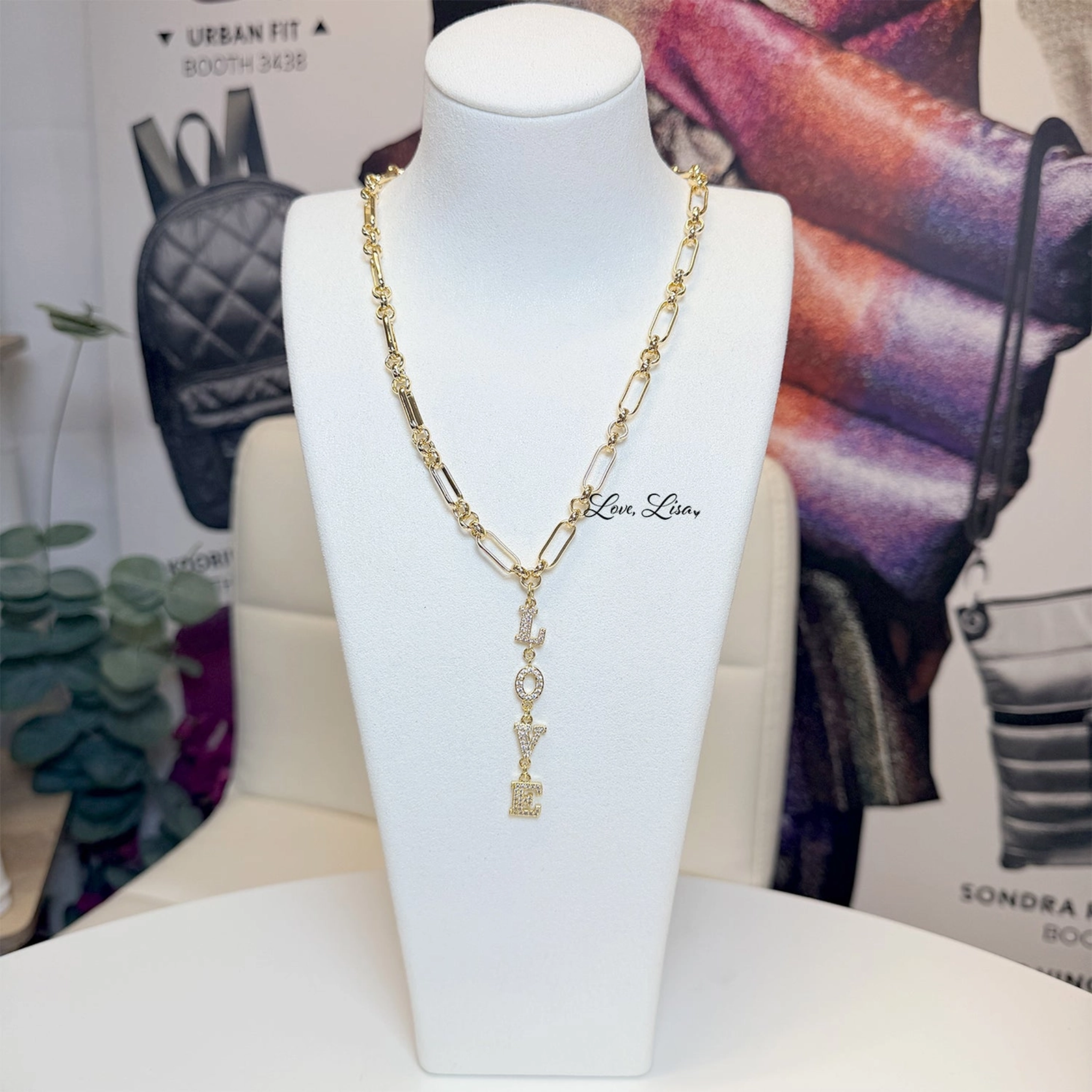 Love Lisa Maeve Love Drop Necklace featuring a delicate pendant with a heart and bow charm on a fine chain.