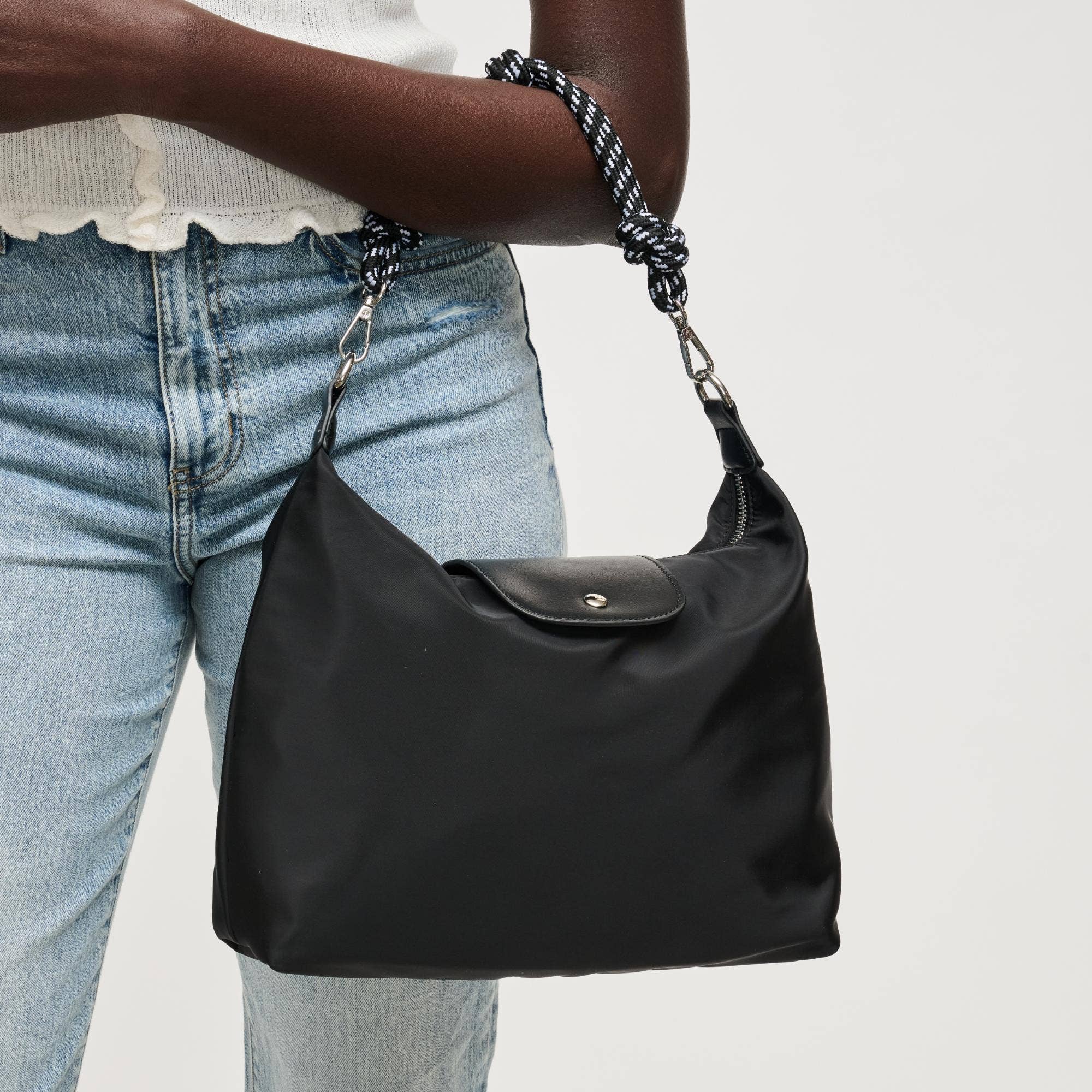 Urban Expressions Nova Hobo bag with tan leather accents and adjustable shoulder strap on a plain background.
