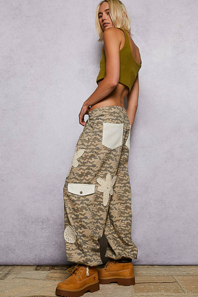 Pol Clothing pleat detail floral patchwork cargo pants with multiple pockets and a relaxed fit, shown on a model.