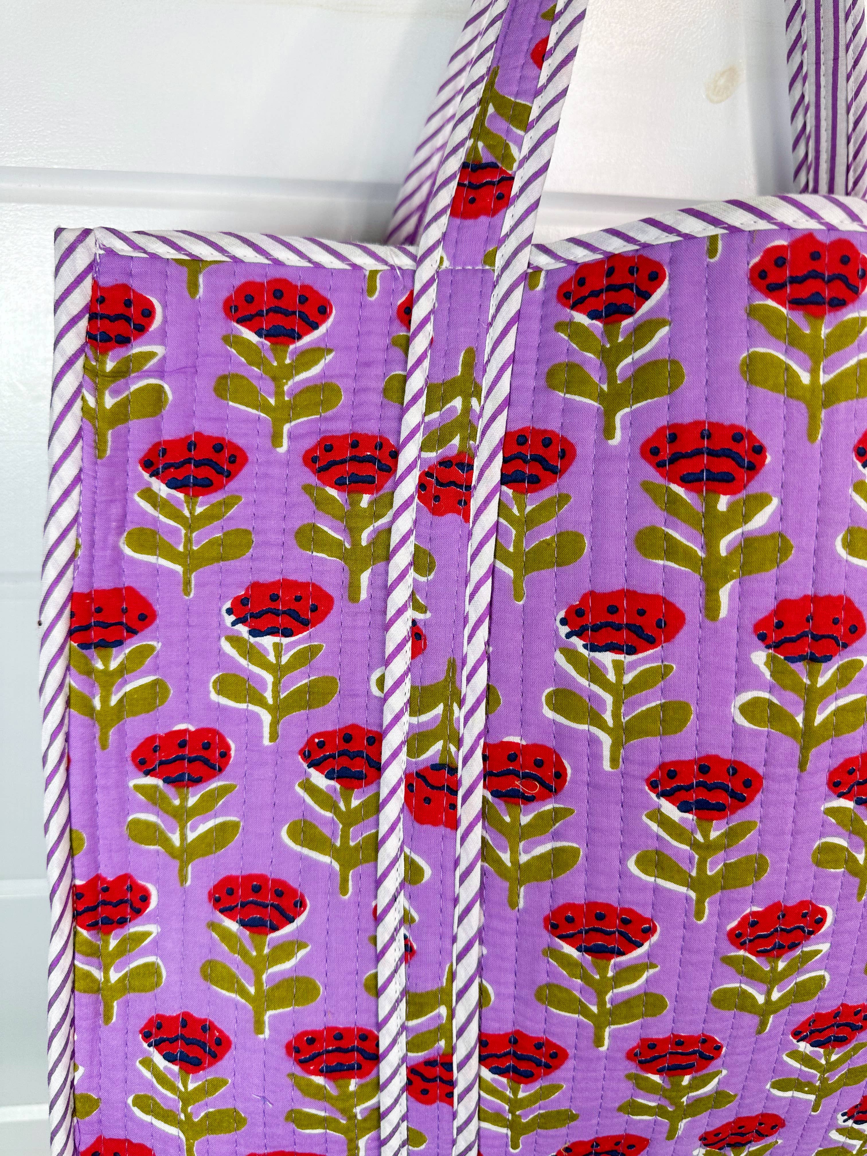 Large purple floral quilted tote bag by Folklore Couture, featuring sturdy straps and a spacious interior for shopping.
