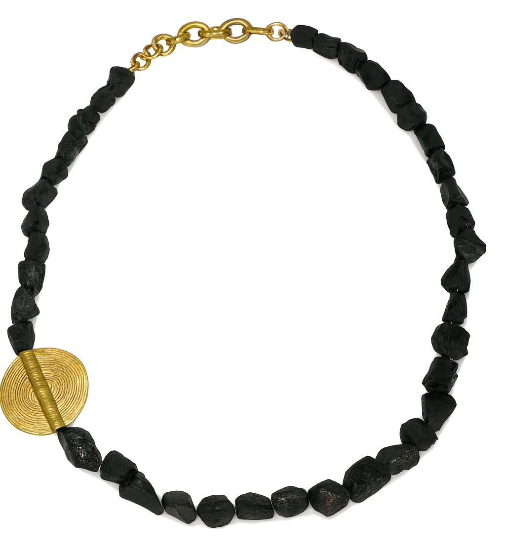 Black beaded necklace with a gold circular pendant on a white background